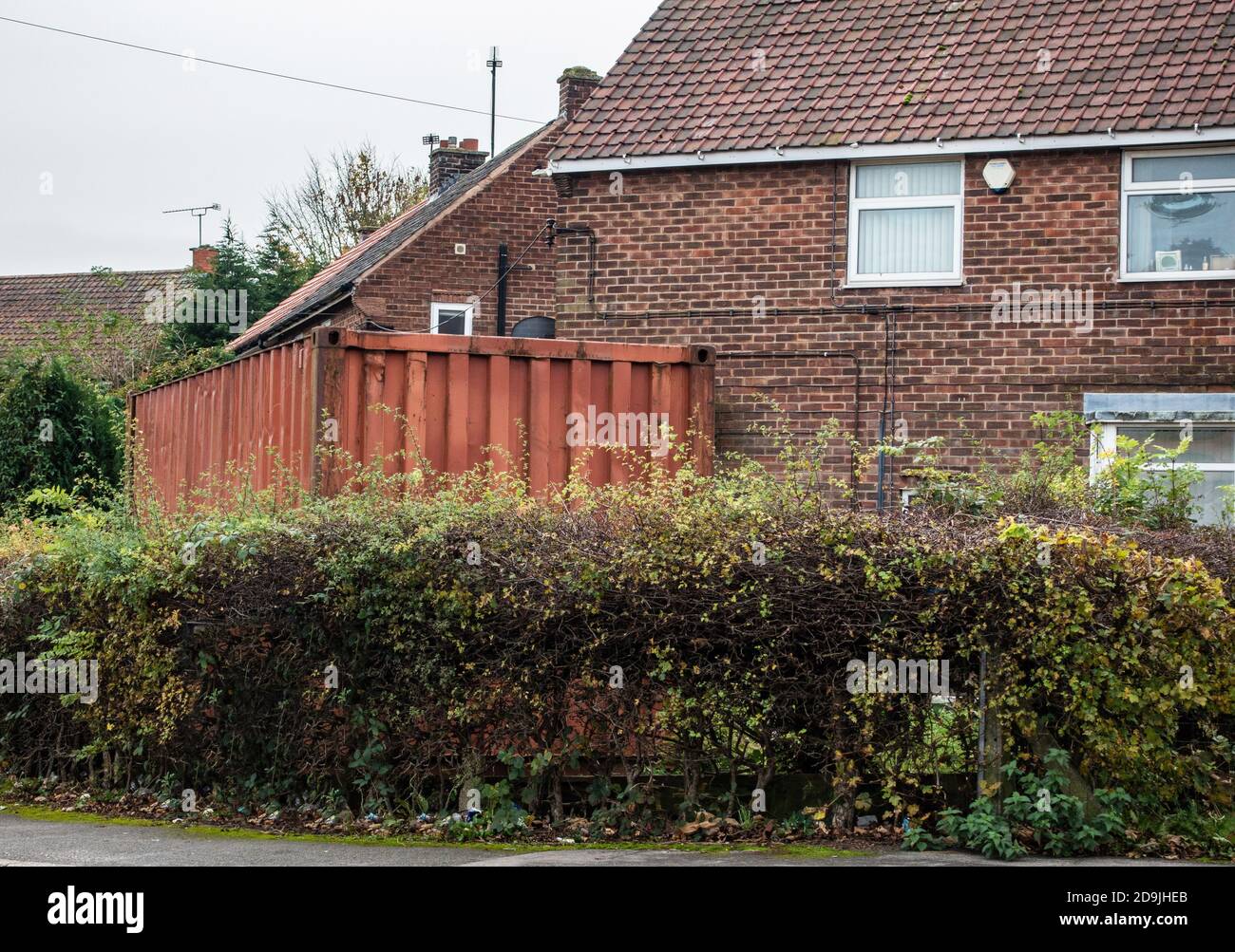Contenitore di spedizione in un giardino anteriore Foto Stock