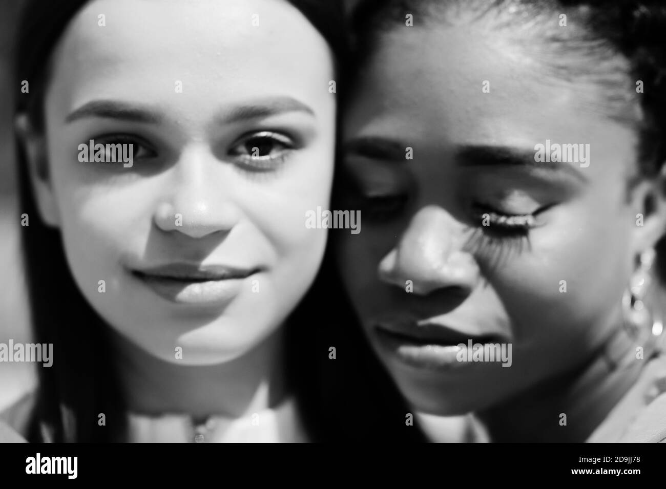 Primo piano volti di bianca caucasica ragazza e nero afroamericano insieme. Unità del mondo, amore razziale, comprensione nella tolleranza e nella diversità delle razze c Foto Stock