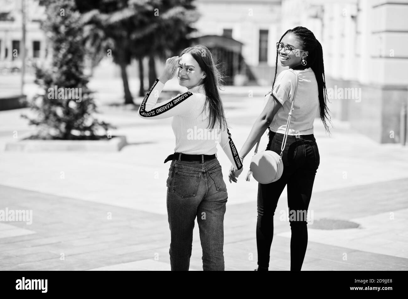 Bianca caucasica ragazza e nero afroamericano tenendo insieme le mani. Unità mondiale, amore razziale, comprensione nella tolleranza e razze diversità coope Foto Stock