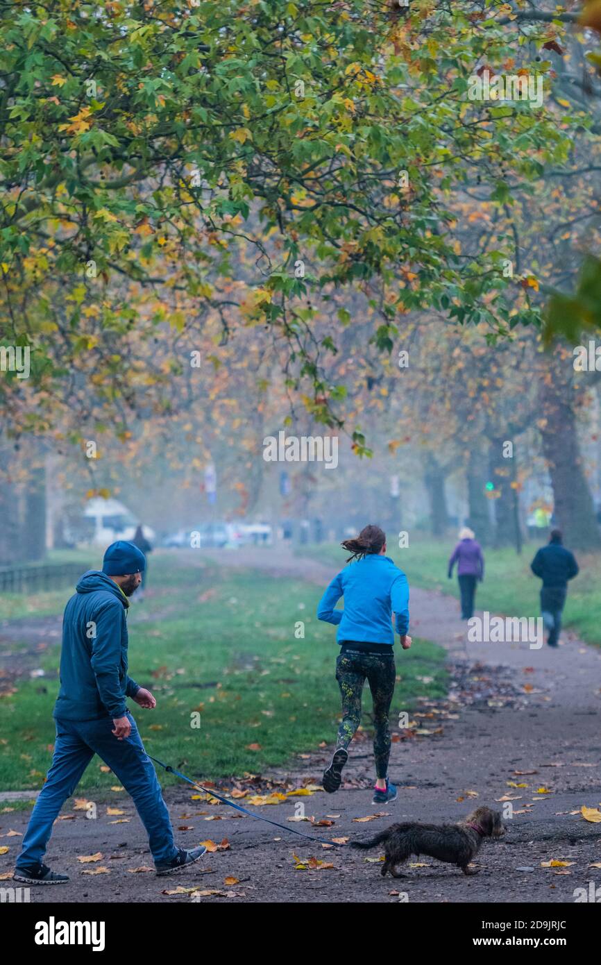 Londra, Regno Unito. 06 novembre 2020. In una mattinata misteriosa, Clapham Common è impegnato con corridori, escursionisti e famiglie in corse a pedali, con uno sfondo di colori autunnali dorati. Le persone stanno tornando a vivere all'aria aperta mentre il Coronavirus Lockdown ritorna. Credit: Guy Bell/Alamy Live News Foto Stock
