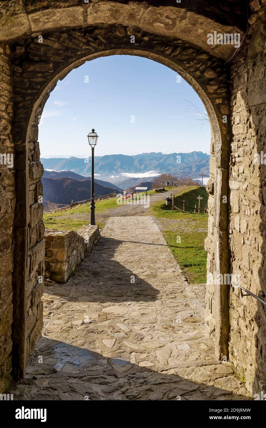 Vista verticale della Garfagnana incorniciata da un arco del Santuario di San Bianco e Pellegrino a San Pellegrino in Alpe Foto Stock