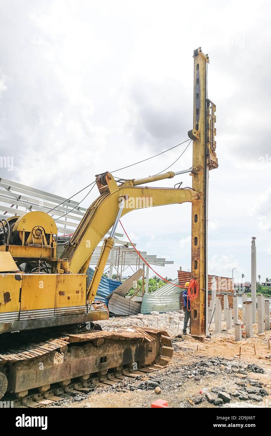 Lavoratore che esegue lavori di impilamento a terra in cantiere Foto Stock
