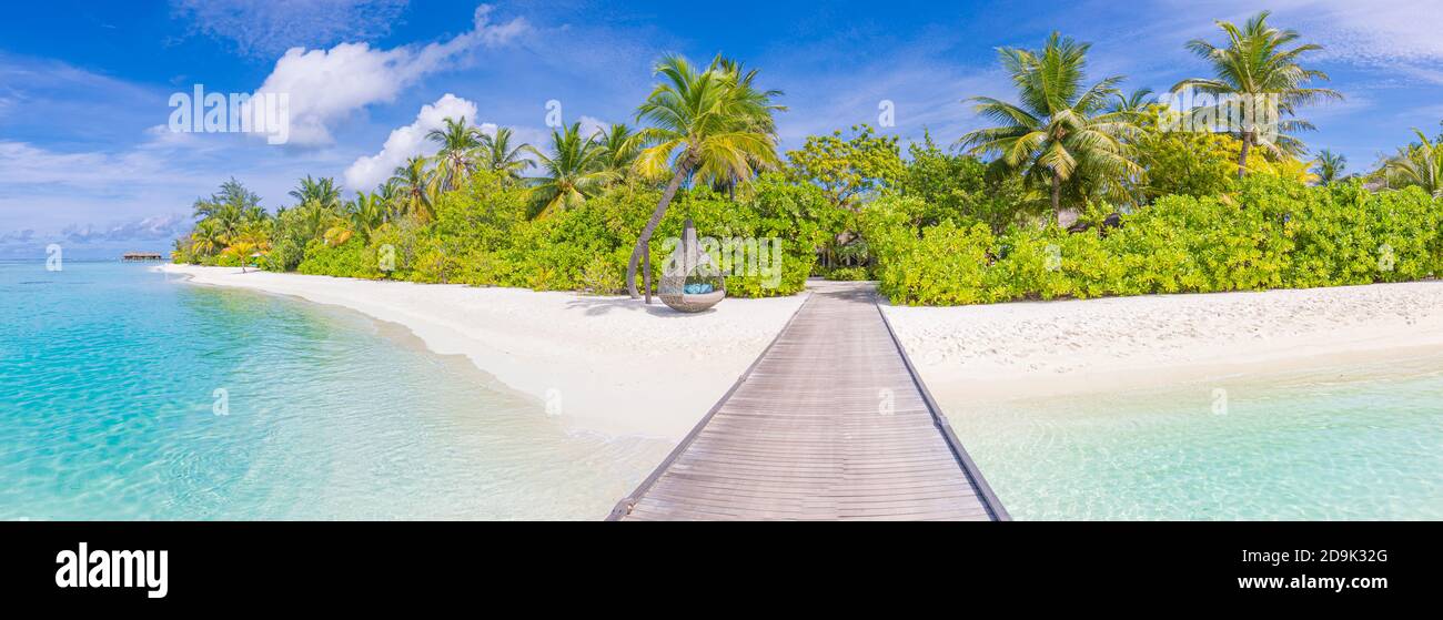 Splendido paesaggio tropicale, viaggi estivi di lusso e vacanze. Molo in legno nell'isola contro il cielo blu con nuvole bianche, vista panoramica Foto Stock