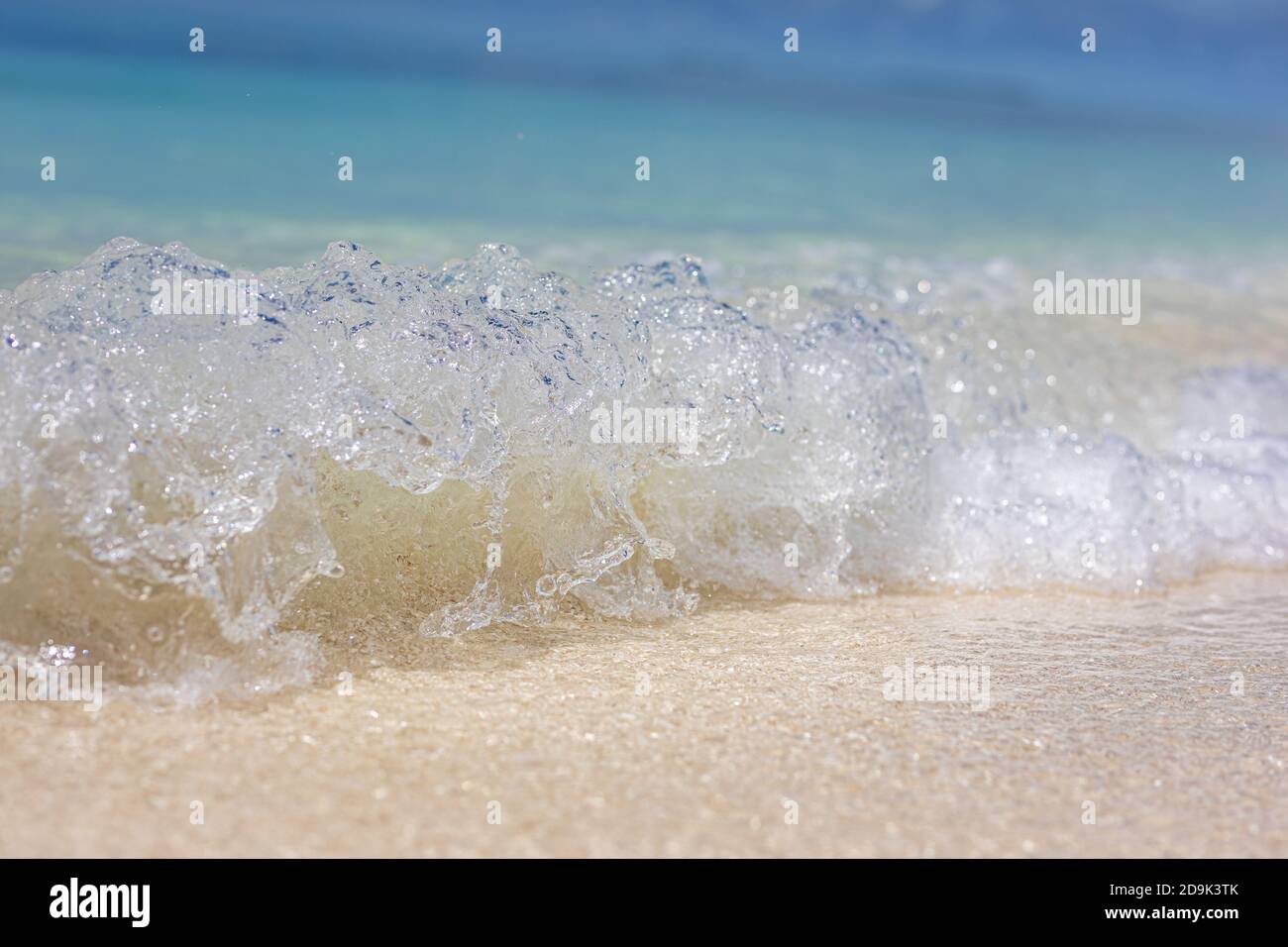 Vista in primo piano delle onde che spruzzi mare spiaggia sabbia sole luce del giorno paesaggio relax. Onde surf, mare astratto acqua oceanica, ambiente, ecologia Foto Stock