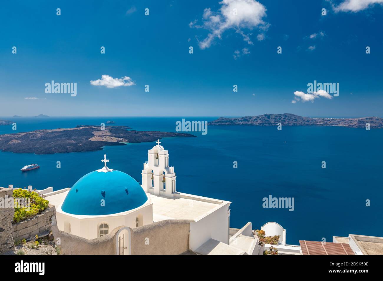 Vista estiva dell'isola nel paesaggio estivo. Thira città sull'isola di Santorini e il mare, paesaggio urbano greco. Cupola blu sopra la vista blu del mare Foto Stock
