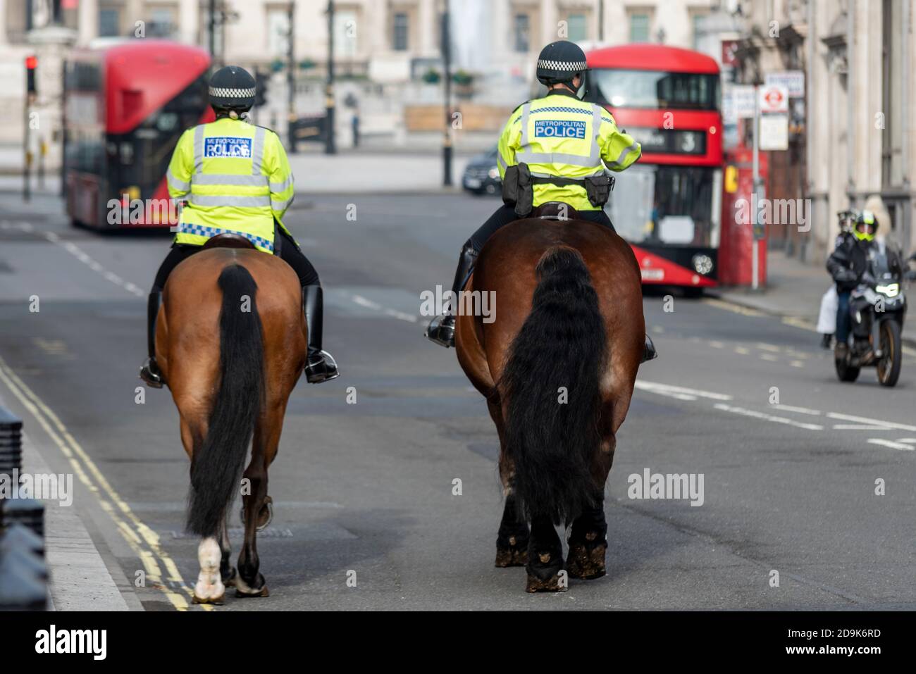 Poliziotti a cavallo a Whitehall, Westminster, Londra, Regno Unito, autobus rossi e motociclette. Silenzio, blocco C19. Cavalieri della polizia metropolitana Foto Stock
