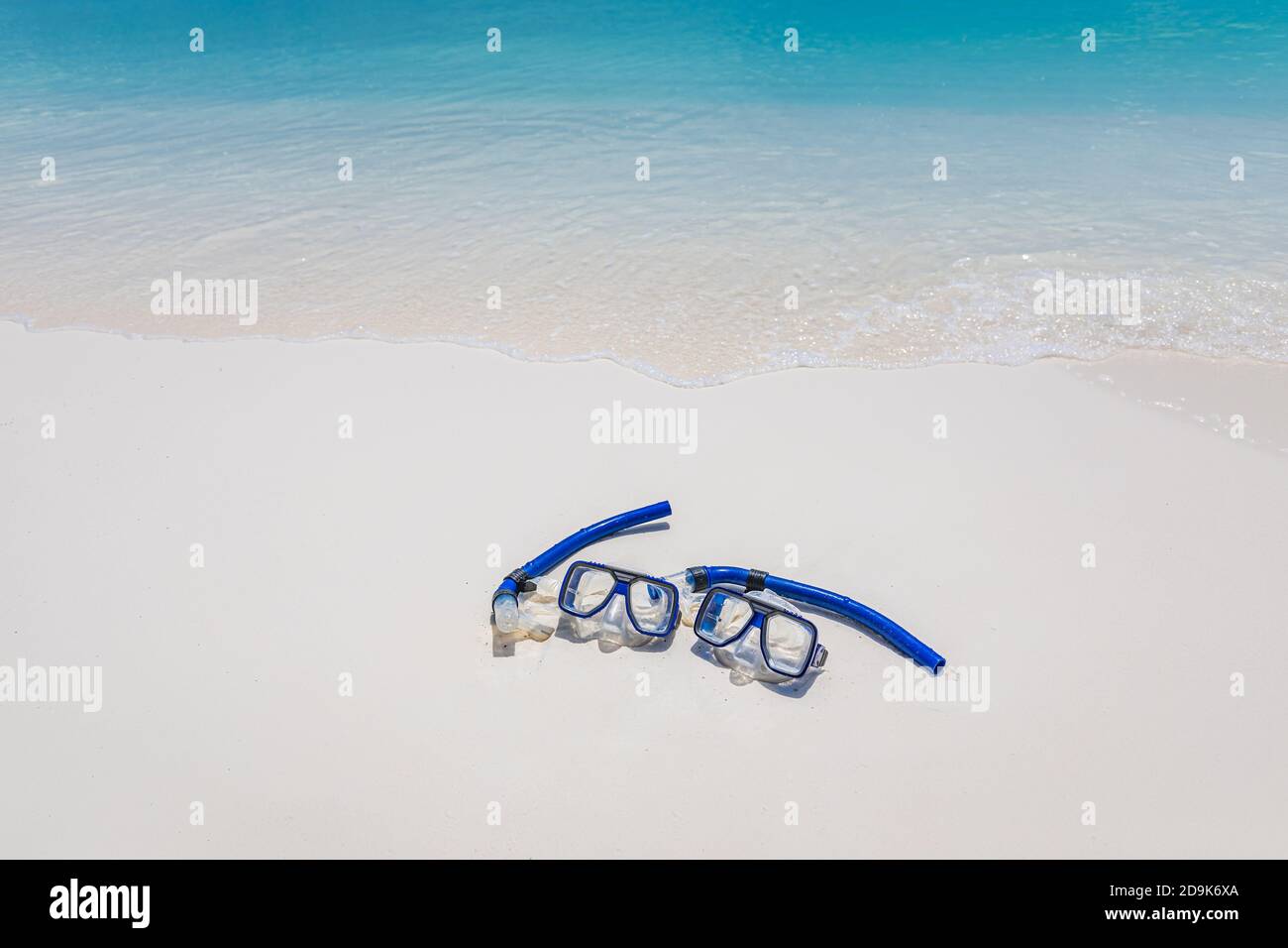 Due maschere e attrezzatura da snorkeling nelle onde di surf della spiaggia di sabbia. Attività sportive esotiche all'aperto, hobby ricreativo. Spiaggia sabbia e vista mare paesaggio Foto Stock