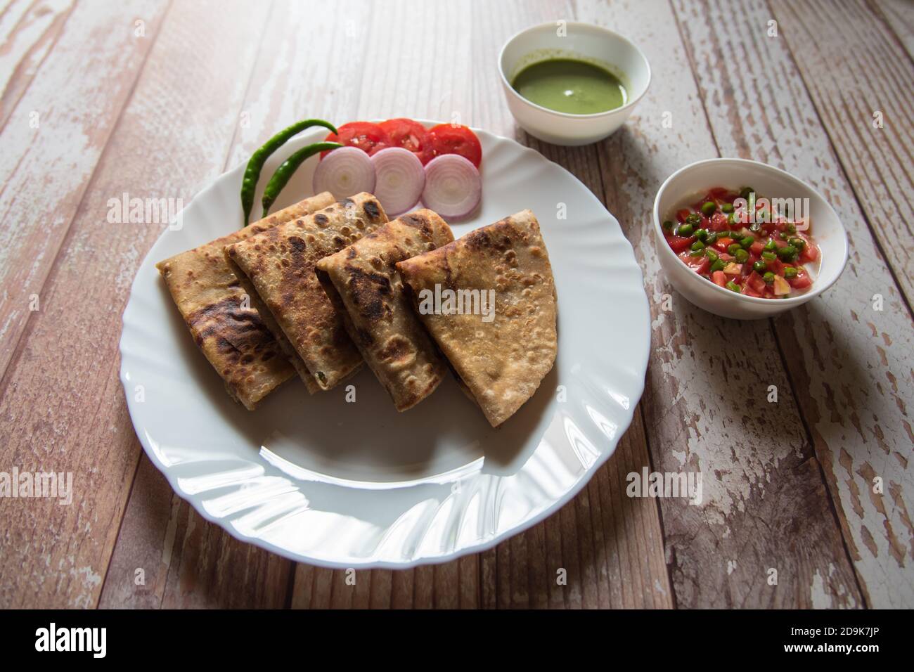 Primo piano di alu paratha o patate farcito pane indiano insieme ai condimenti Foto Stock