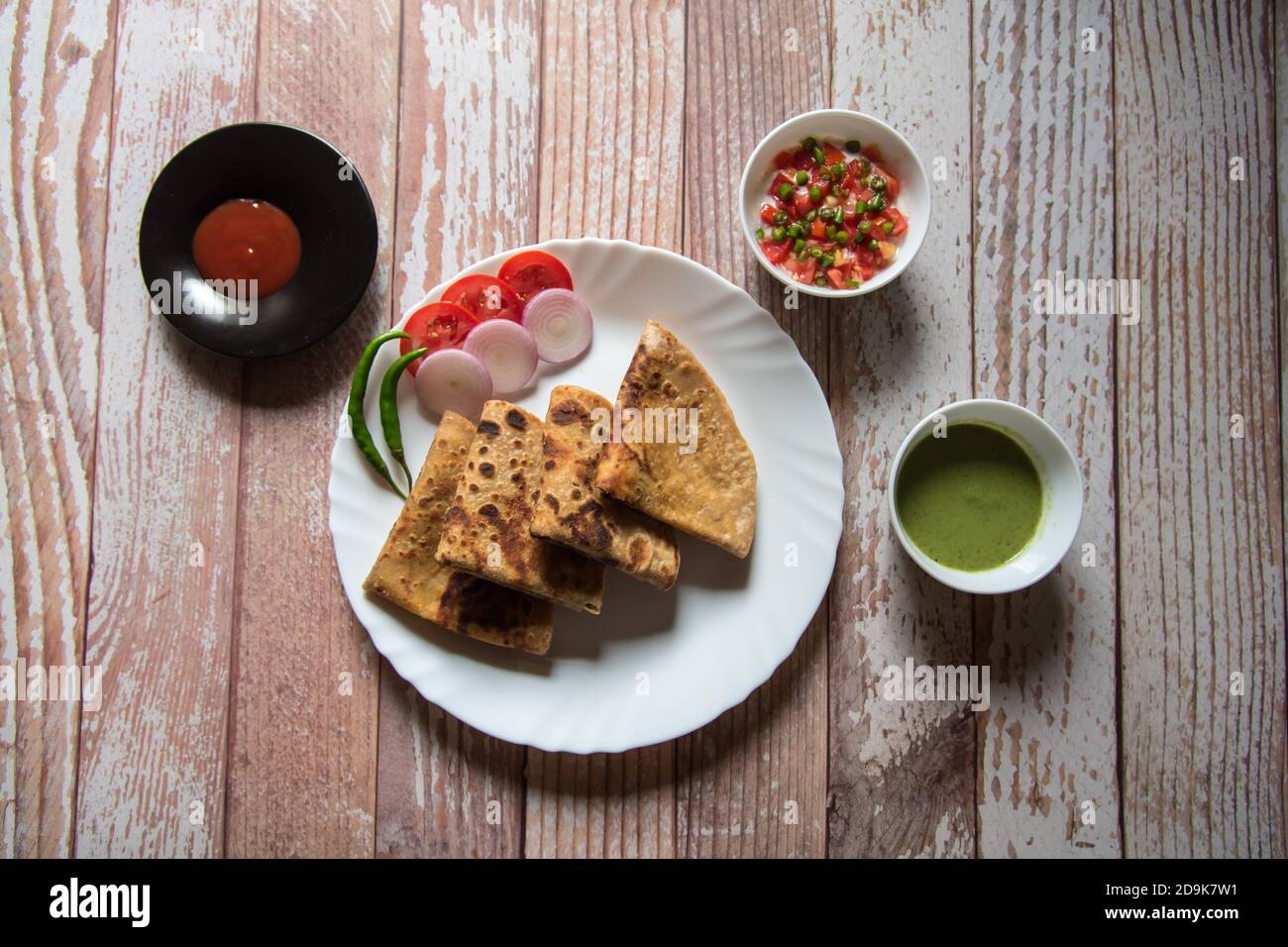 Vista dall'alto dell'alu paratha insieme agli ingredienti per la colazione Foto Stock
