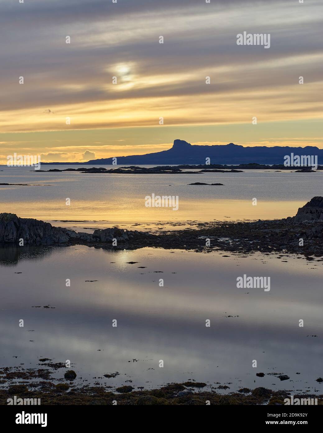 Tramonto sull'isola di Eigg nelle piccole isole, vista dalla penisola di Rhu, Arisaig, Lochaber, Highland, Scozia. Foto Stock