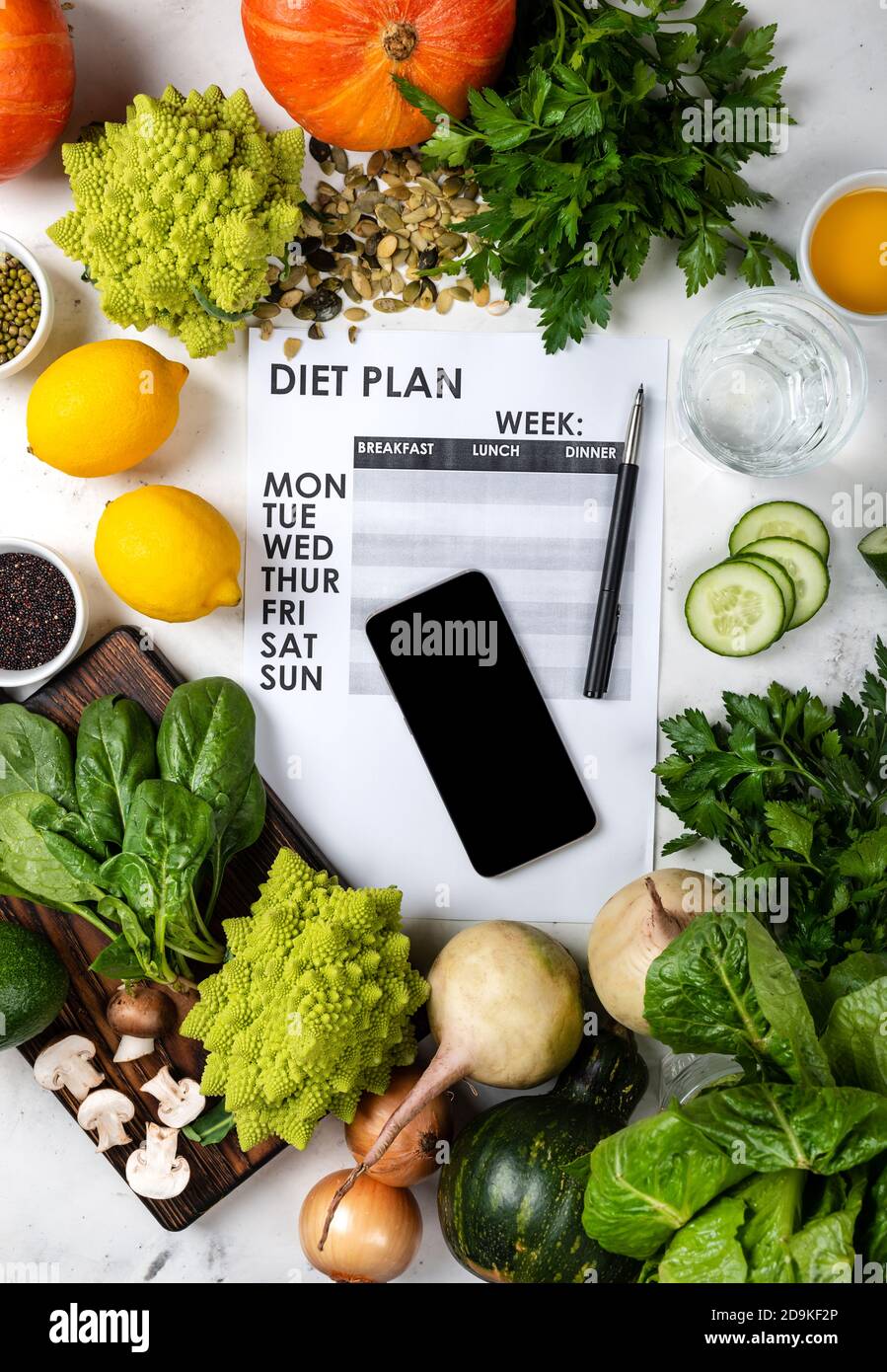 Concetto di peso perso. Smartphone Dieta piano e set di alimenti sani Foto Stock