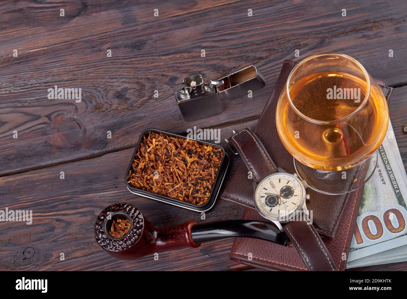 Fumatore pipa con tabacco e bicchiere di brandy. Foto Stock