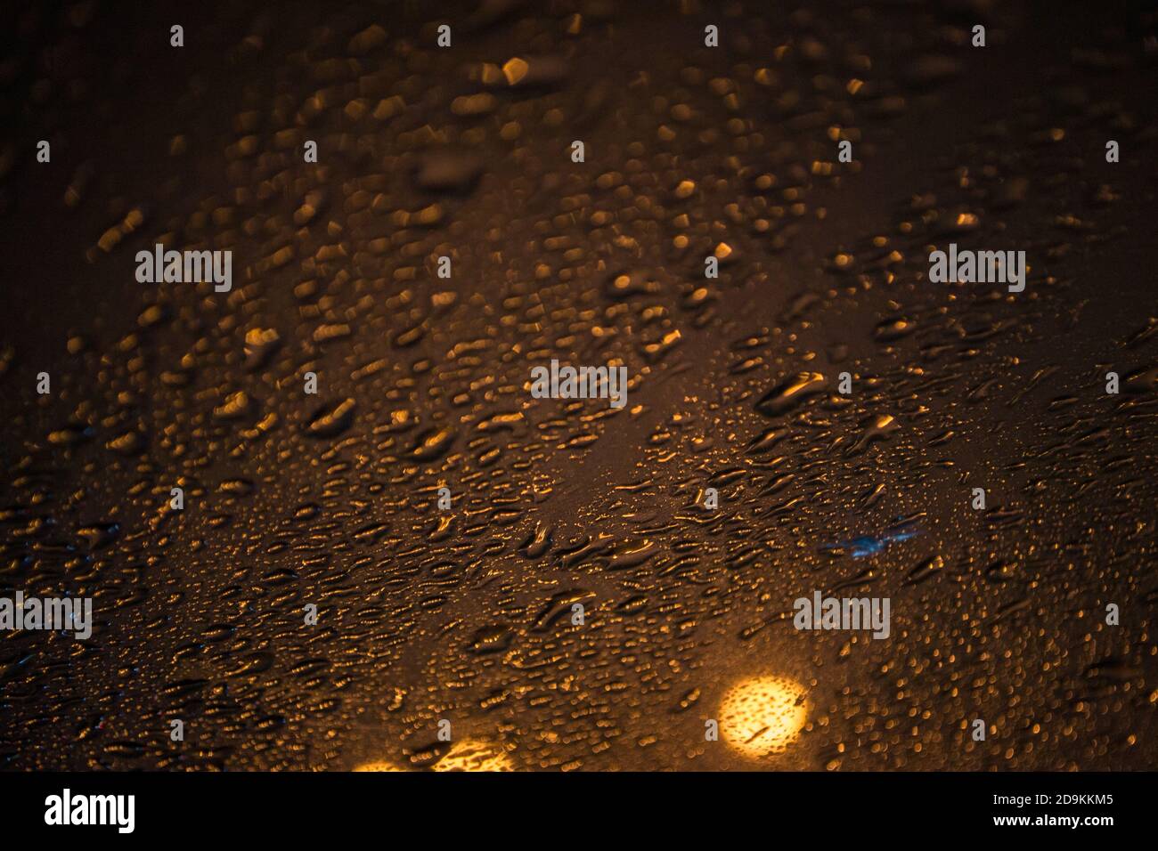 gocce d'acqua naturali su vetro, foto notturna con luci di strada all'esterno. Sfondo fatto di gocce, fuoco selettivo, posto per il testo Foto Stock