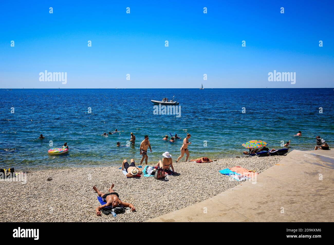 Piran, Istria, Slovenia - vita da spiaggia sulla spiaggia della città Fornace nella città portuale di Piran sul Mediterraneo. Foto Stock