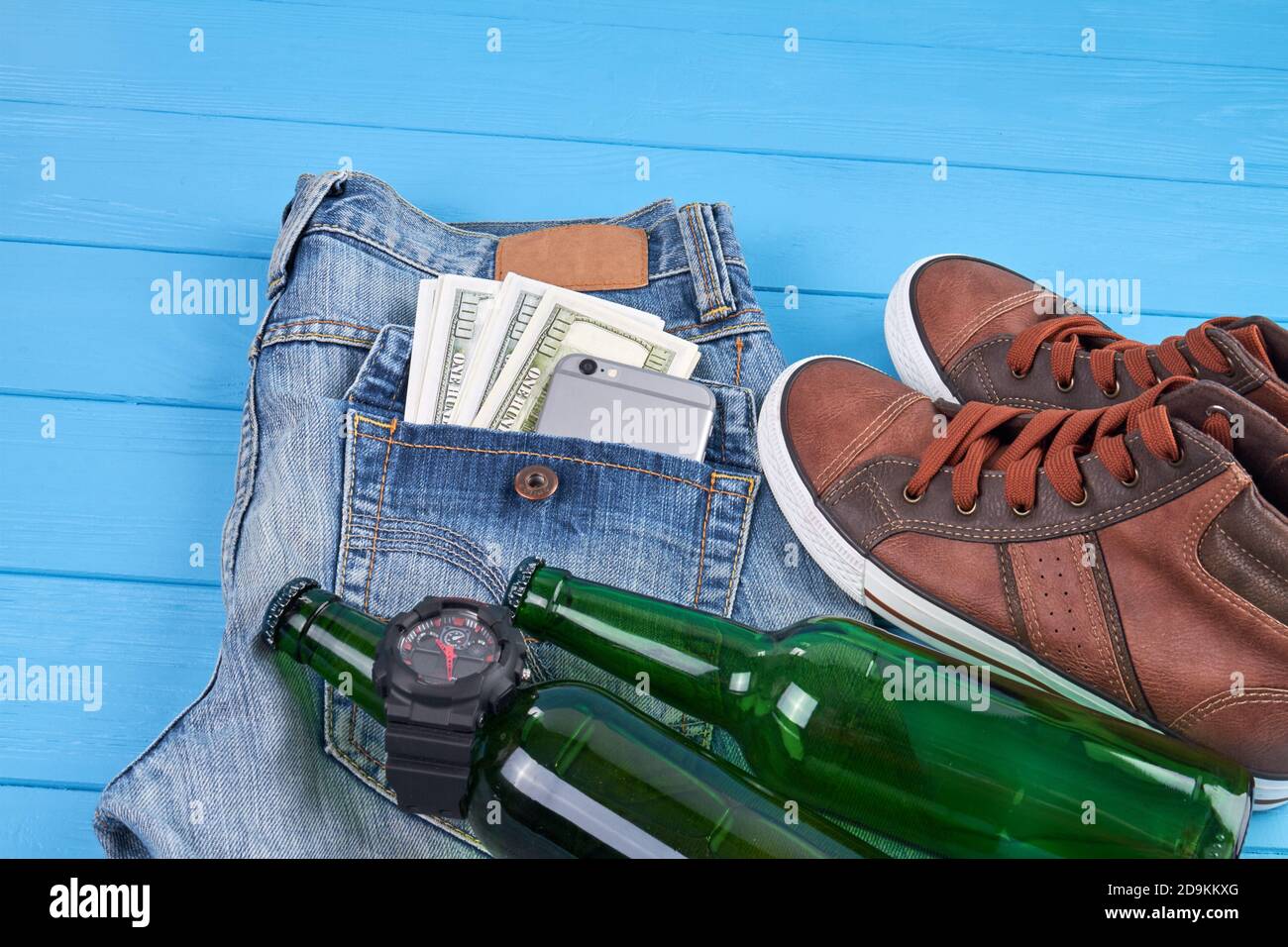 Sneakers con bottiglia e jeans. Foto Stock