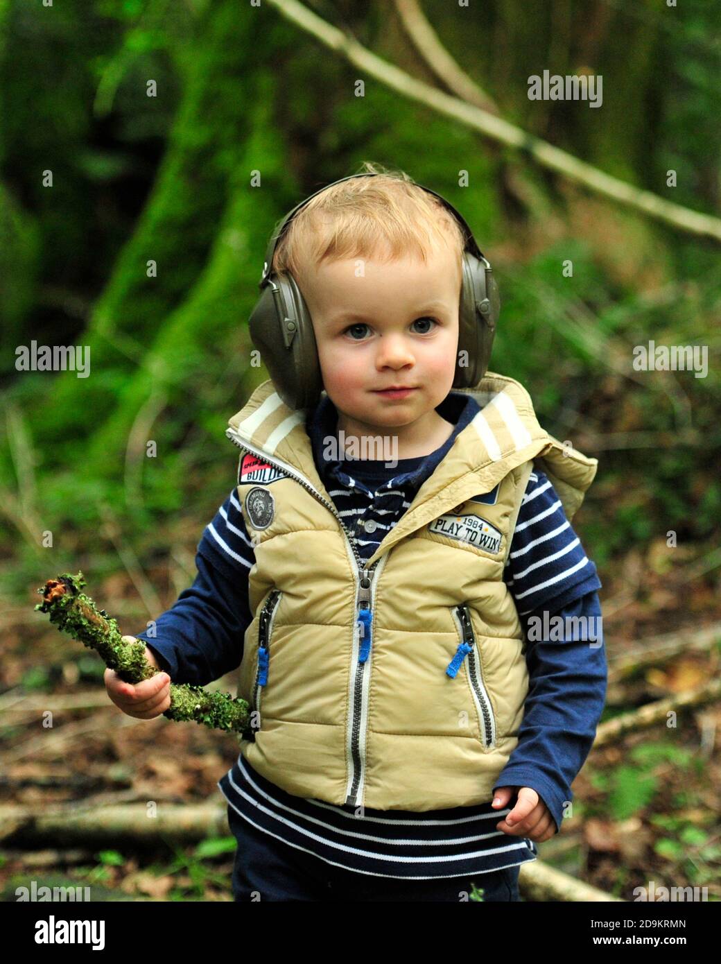 bambino piccolo che indossa cuffie protettive durante un tiro di gioco Foto Stock