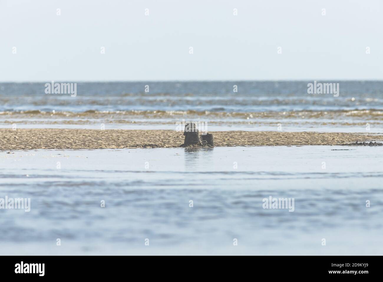 Piccolo edificio di un piccolo artista - castello di sabbia nel mare di Wadden, la marea sta arrivando Foto Stock