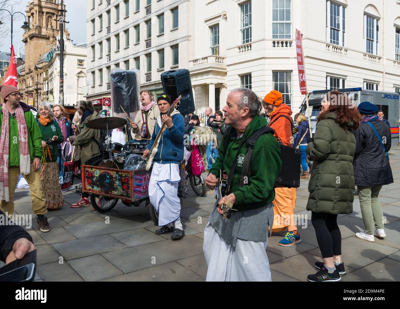 Una band di musicisti Hare Krishna intrattiene persone a Charing Cross Road durante una marcia di protesta nel centro di Londra, Inghilterra, Regno Unito. Foto Stock