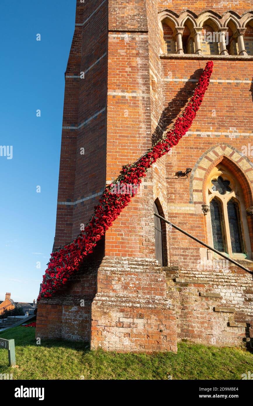 Lyndhurst, Hampshire, Regno Unito. 6 novembre 2020. Il Poppy Appeal ha dovuto adattarsi quest'anno a causa del secondo blocco in Inghilterra a causa della pandemia del Coronavirus covid-19, e la gente ha trovato modi diversi per commemorare la Giornata della memoria. La Chiesa di San Michele e tutti gli Angeli di Lyndhurst è stata decorata con papaveri rossi a maglia realizzati dalla comunità locale per creare una "caduta di papaveri per i nostri caduti". Foto Stock