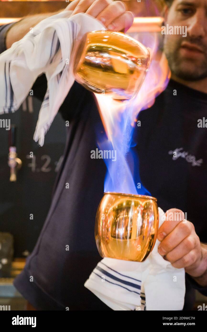 Man mescola bevande in fiamme in un bar di New York Città Foto Stock