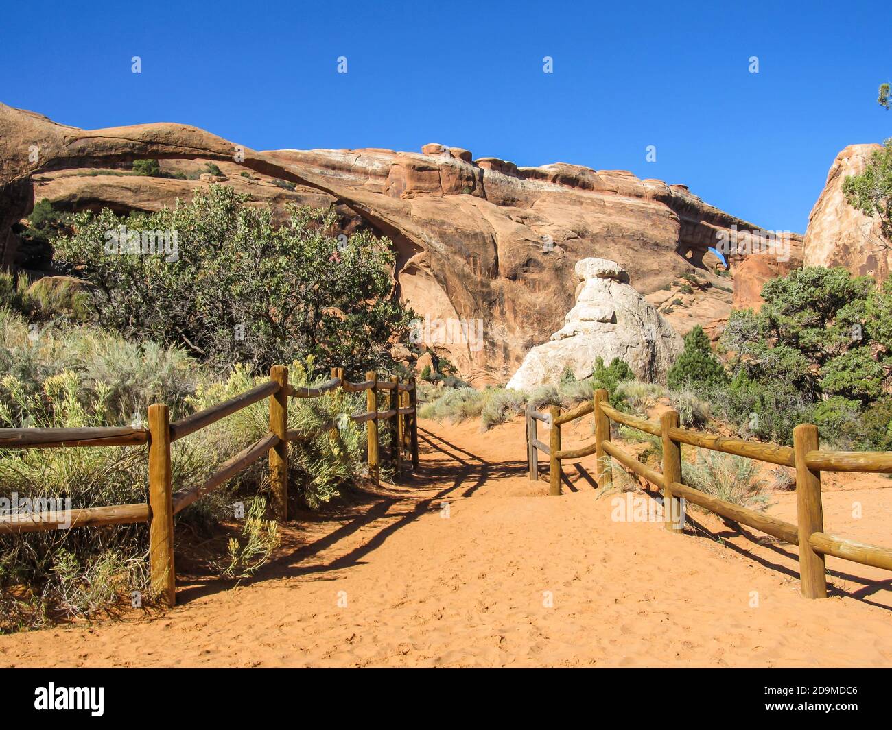 Un sentiero che conduce verso un punto di osservazione su Paesaggio e Arco di partizione, due degli archi della sezione Giardino del Devils del parco nazionale Arches Foto Stock