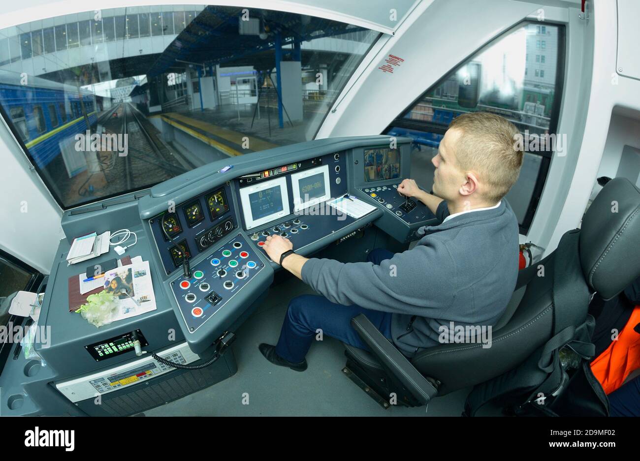 Autista del treno seduto nella cabina della locomotiva del passeggero treno pronto per la partenza Foto Stock