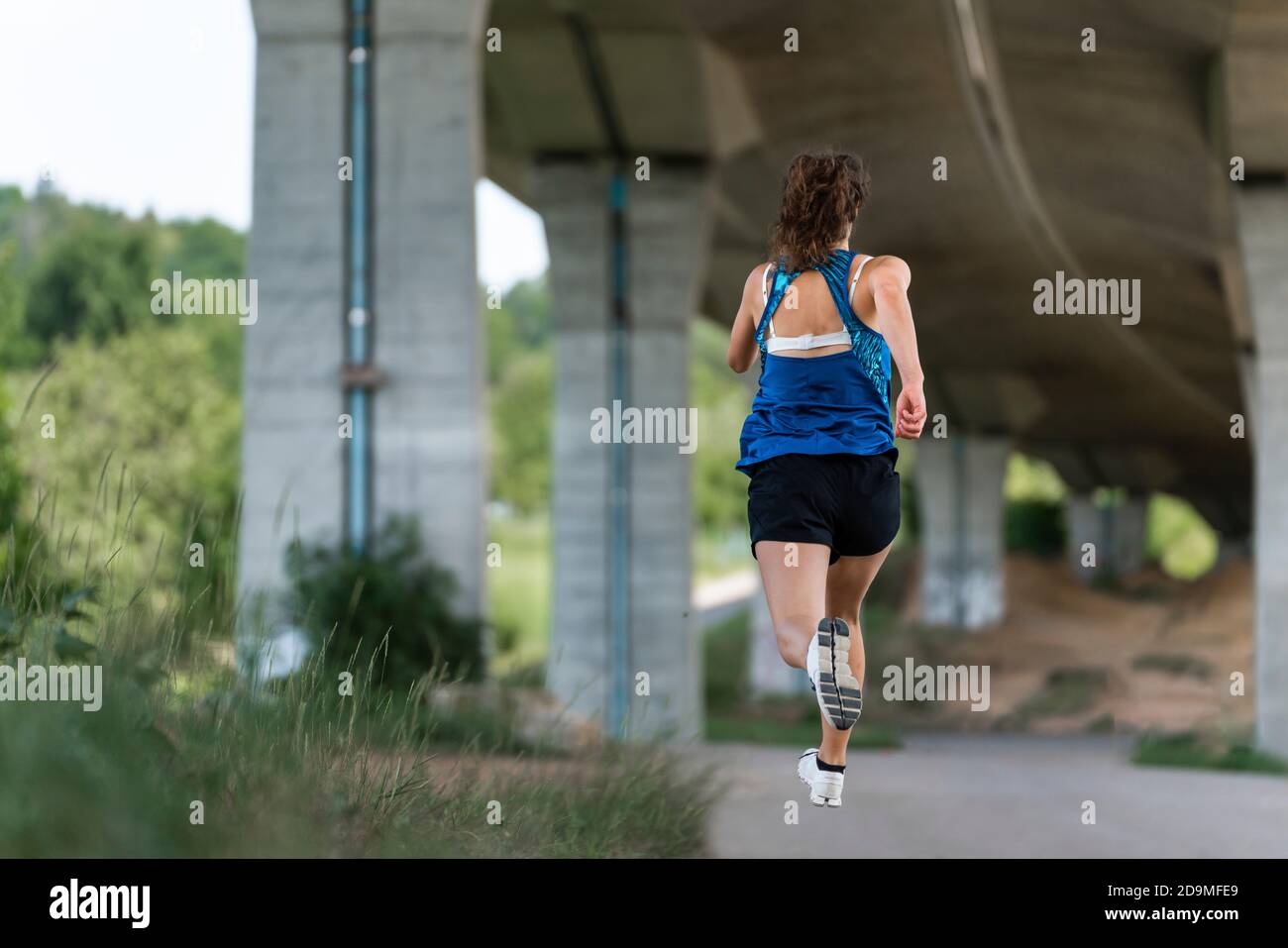 Donna, 24 anni, che corre sotto un ponte, Remstal, Baden-Württemberg, Germania Foto Stock