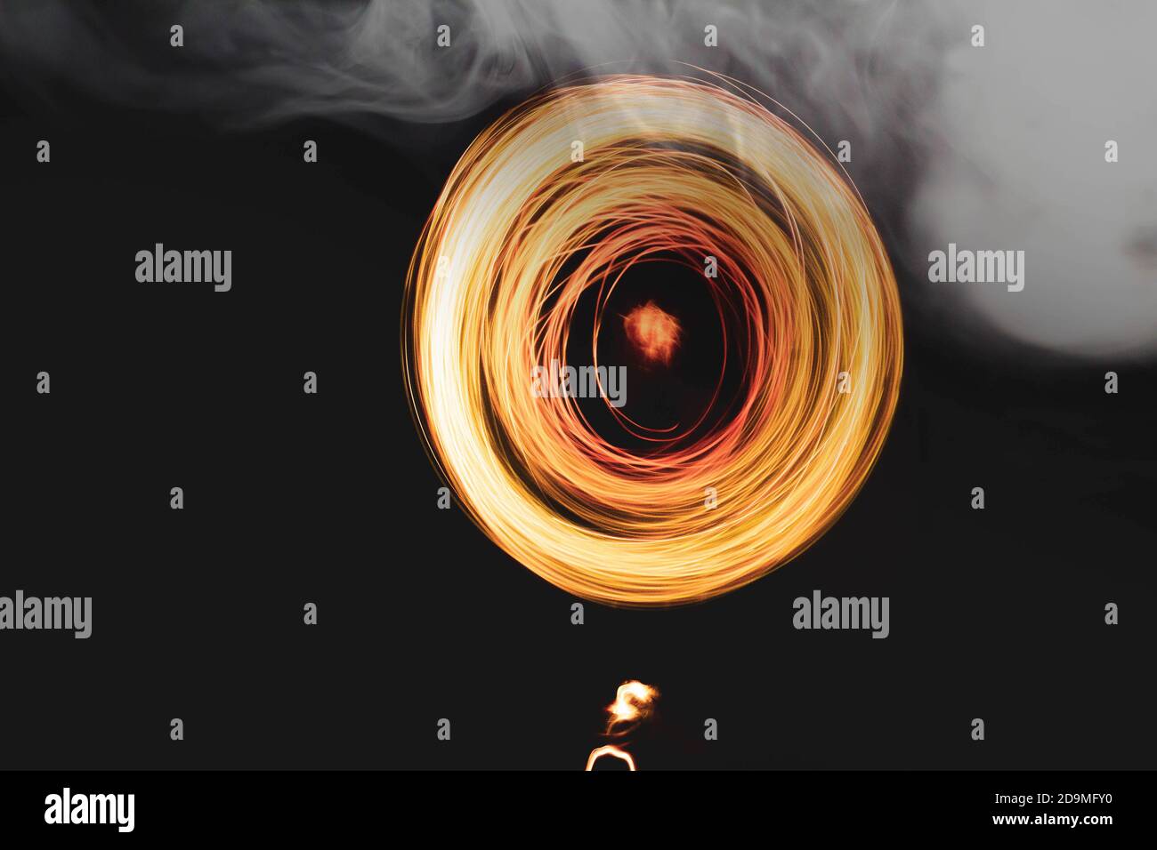 mano con fuoco e spirale leggera che crea fumo bianco Foto Stock