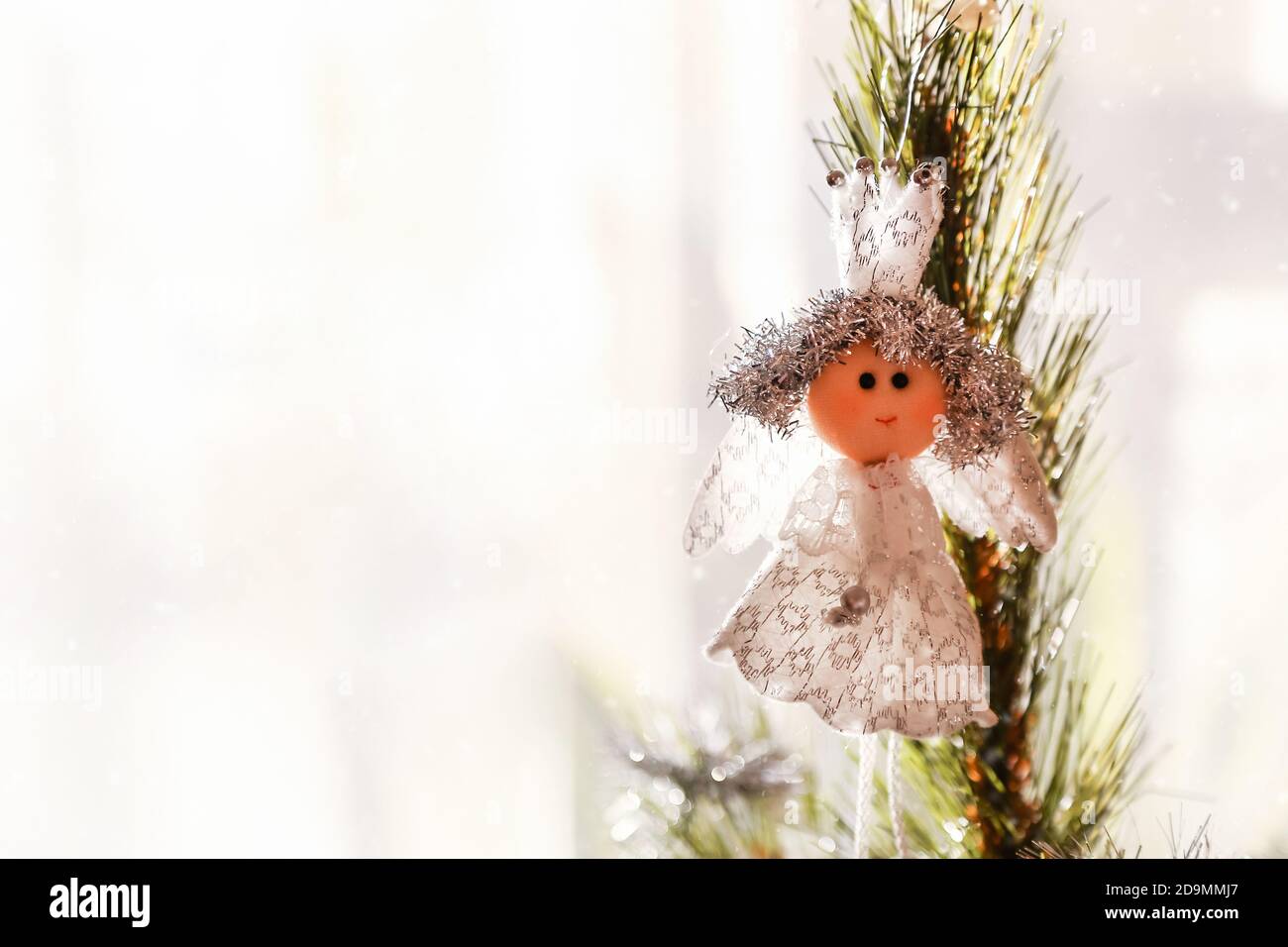 Natale, Capodanno sfondo. Cima dell'albero di natale decorato con la principessa giocattolo poco sullo sfondo luminoso della finestra. Vacanze invernali Foto Stock