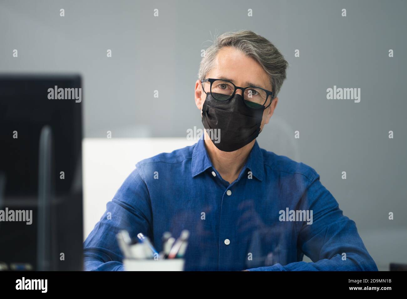 Receptionist in maschera presso il Medical Center Covid Office Foto Stock