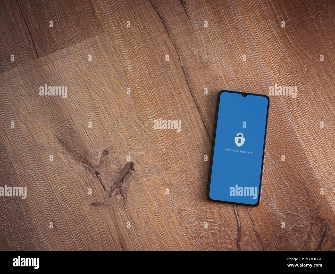 LOD, Israele - 8 luglio 2020: Schermata di avvio dell'applicazione Microsoft Authenticator con logo sul display di uno smartphone nero su sfondo in legno. In alto Foto Stock