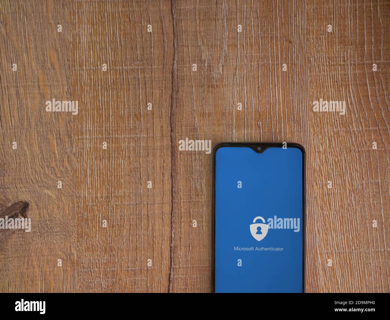 LOD, Israele - 8 luglio 2020: Schermata di avvio dell'applicazione Microsoft Authenticator con logo sul display di uno smartphone nero su sfondo in legno. In alto Foto Stock