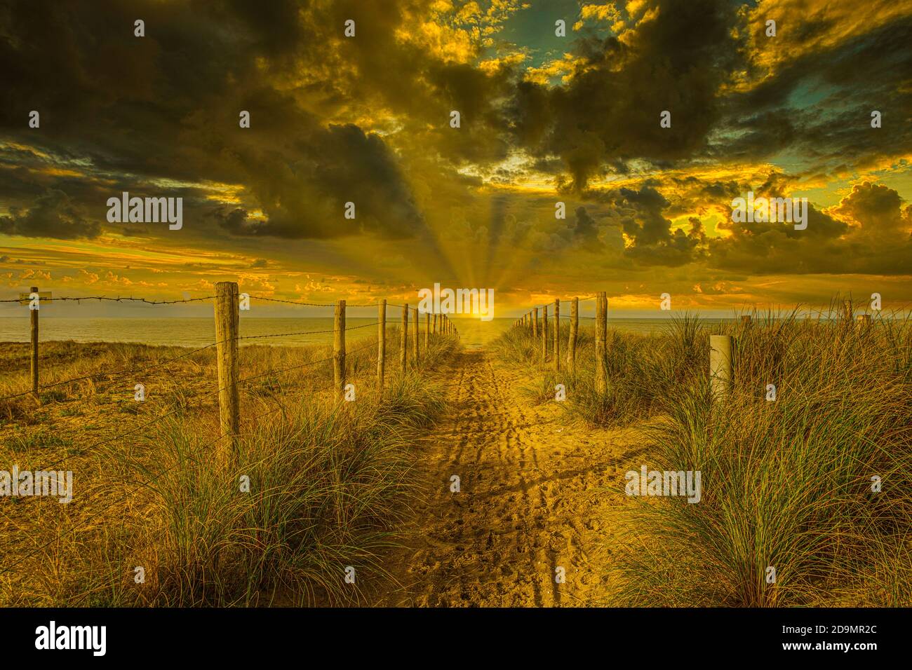 Paesaggio costiero al tramonto e ultimi raggi del sole brillare appena sopra l'orizzonte mentre girano il paesaggio e nuvola coprire in un bellissimo e sorprendente Foto Stock