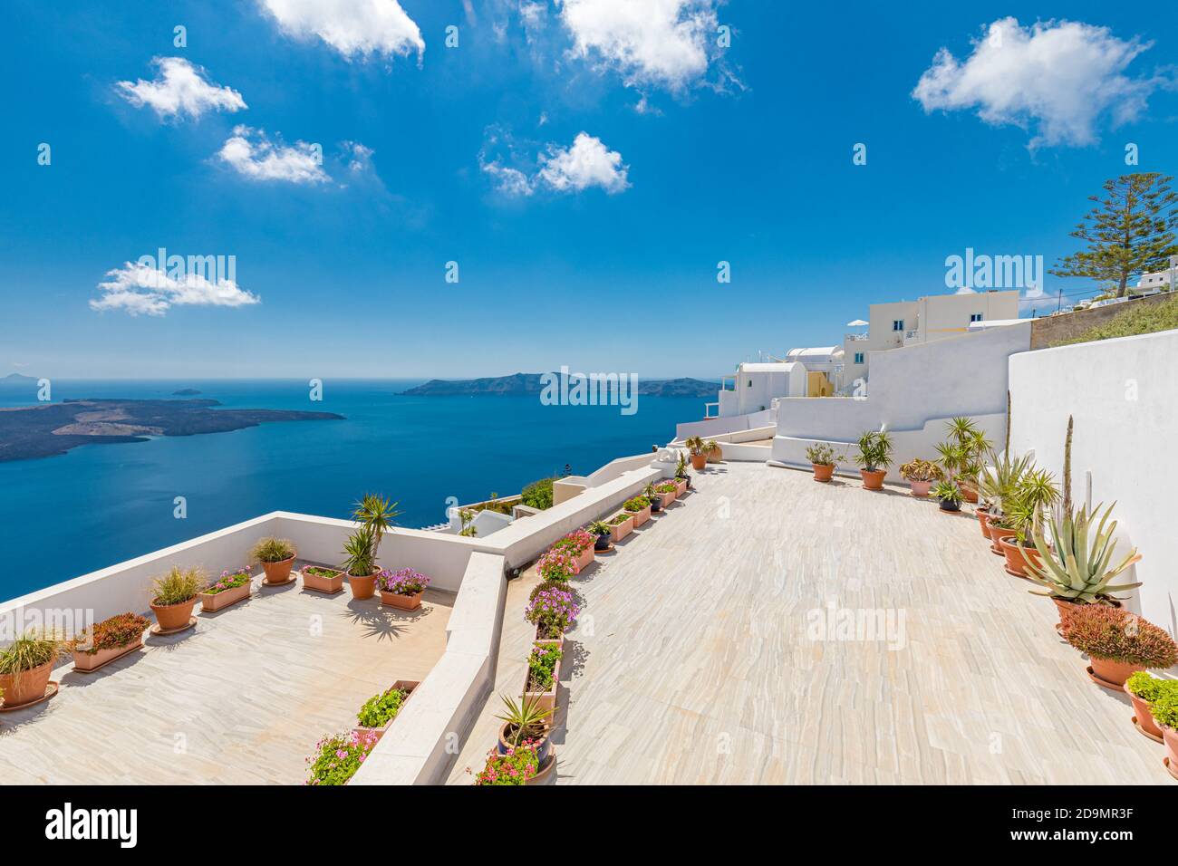 Bellissima terrazza a Santorini con vista mozzafiato. Vasi da fiori con vista pittoresca sulle tradizionali case delle cicladi di Santorini Foto Stock