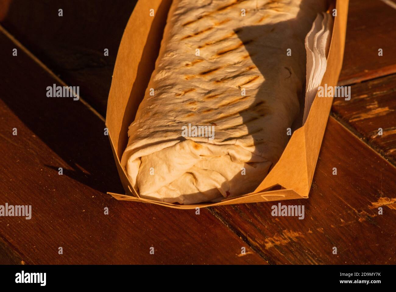 Ciambellotto Kebab Gyros Shawarma rotolo di manzo in pitta pane Wrap sandwich su sfondo di legno. Shawarma Foto Stock