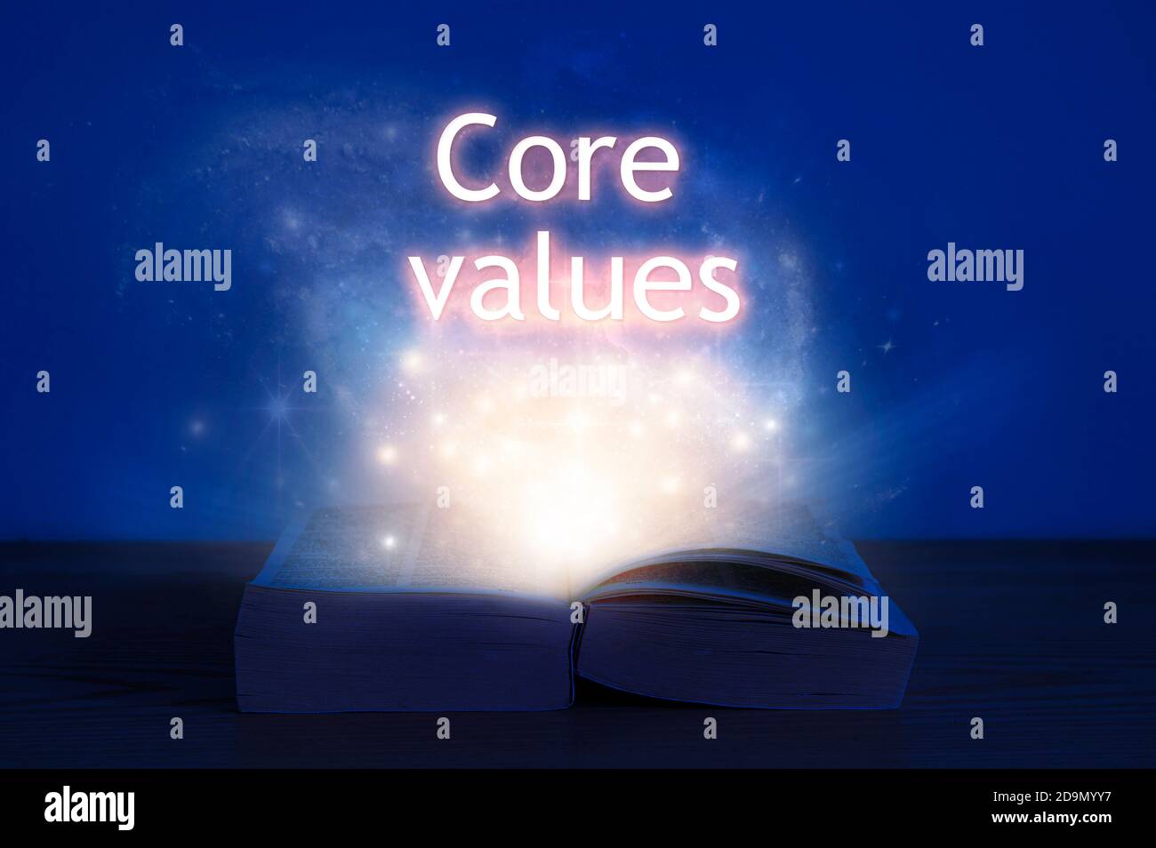 Aprire il libro con l'iscrizione dei valori principali. Luce proveniente da libro aperto con parole valori fondamentali. Foto Stock