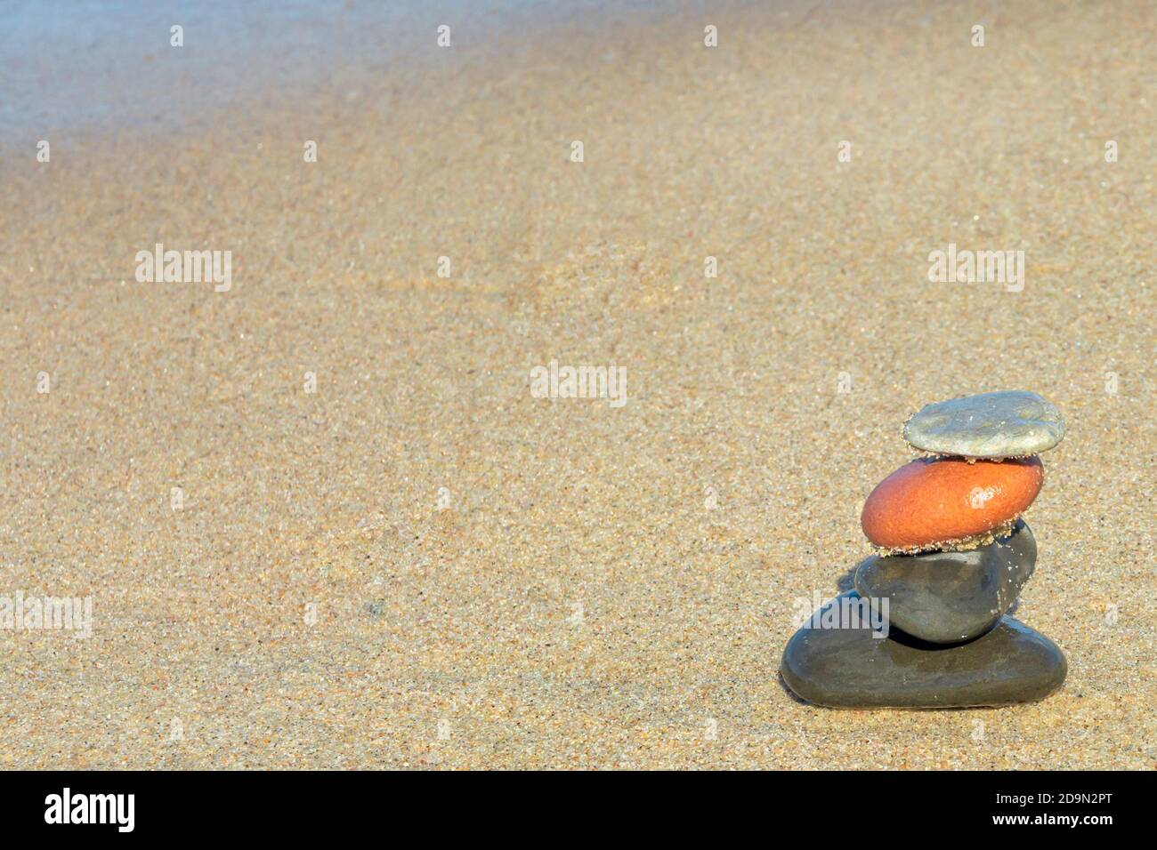 Piramide di pietre sulla sabbia del mare. Concetto di armonia e meditazione. Spazio di copia, messa a fuoco selettiva. Foto Stock