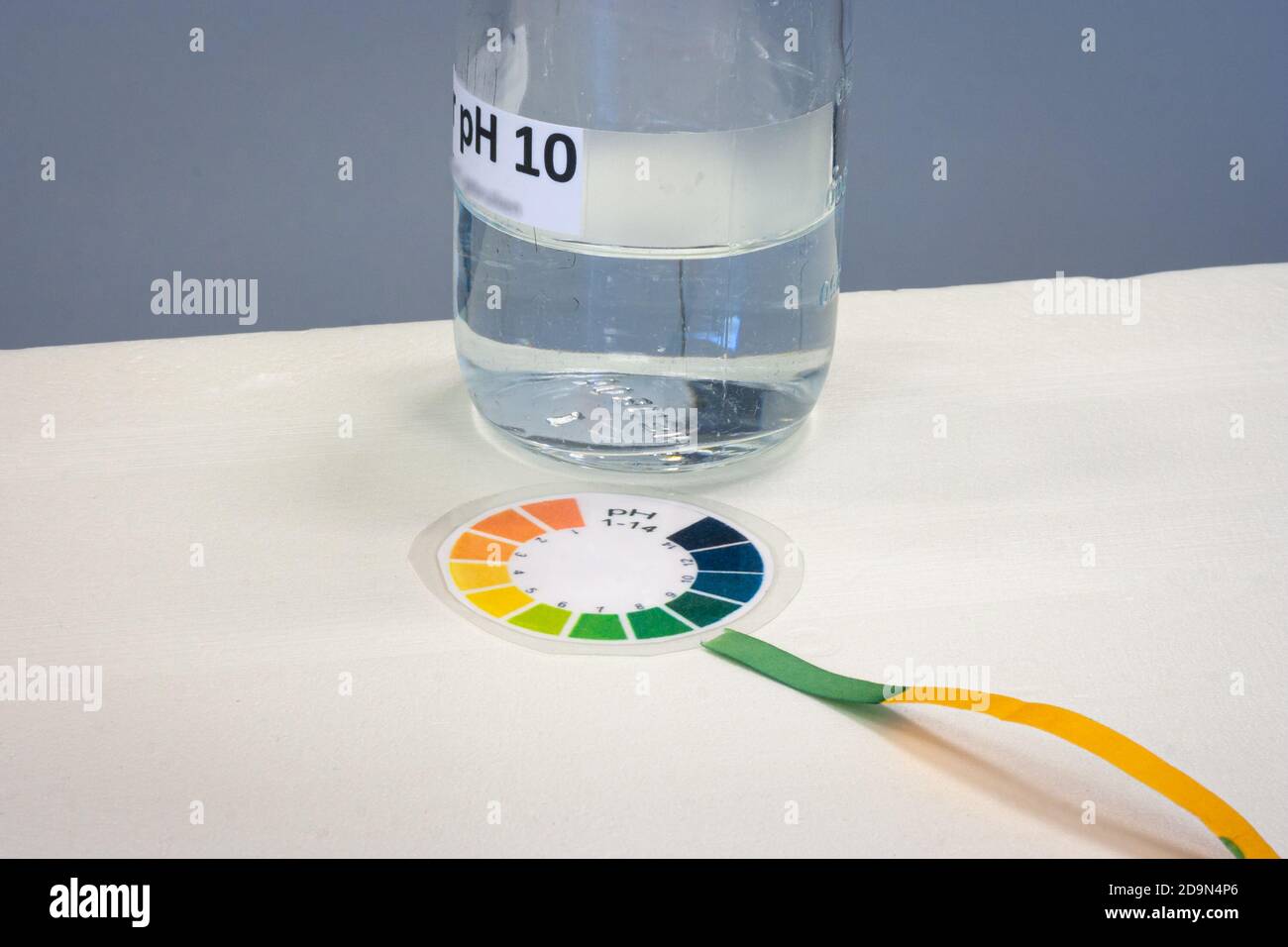 Striscia di prova con grafico a colori della carta di tornasole per determinare il acidità di un liquido Foto Stock