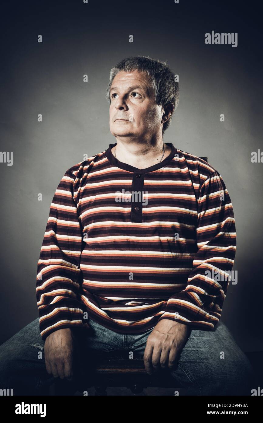 Ritratto di un uomo in studio di mezza età su sfondo grigio Foto Stock