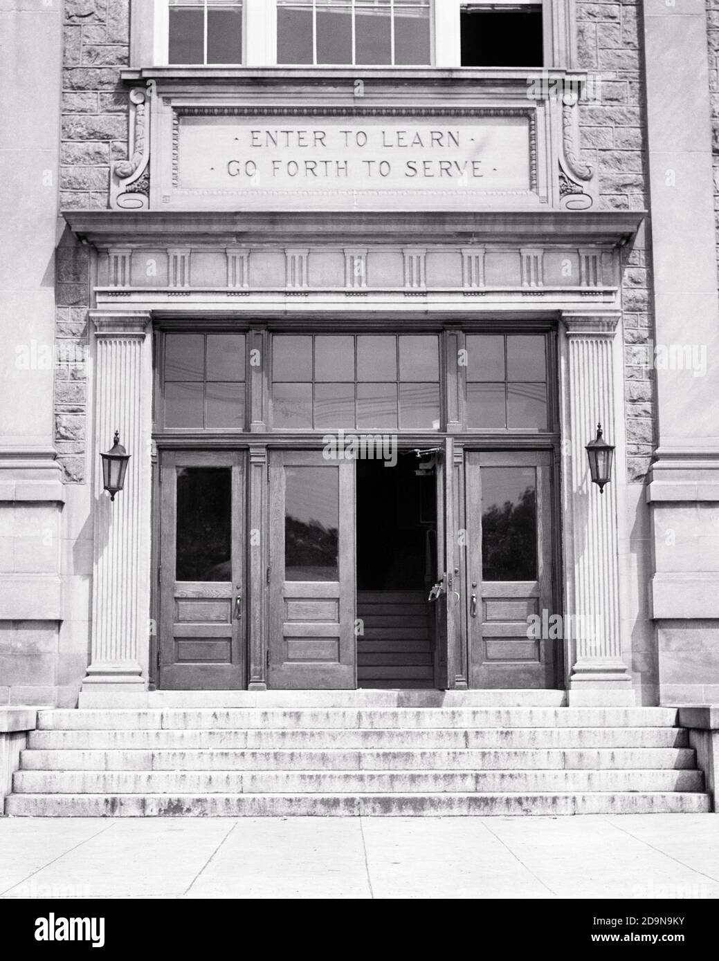 GLI ANNI TRENTA ENTRANO PER IMPARARE ANDARE AVANTI PER SERVIRE IL MOTTO SOPRA INGRESSO FRONTALE DELL'EDIFICIO PUBBLICO DELLA SCUOLA SUPERIORE, UNA PORTA IN PIEDI APERTO - S8485 HAR001 SIMBOLI EDIFICI HARS B&W NORD AMERICA OBIETTIVI DI LIBERTÀ IL SUCCESSO NORDAMERICANO SOGNI STRUTTURA SCOPERTA PROPRIETÀ ESTERNO CONCETTO CONCETTUALE DI LEADERSHIP DI CONOSCENZA A BASSO ANGOLO DI OPPORTUNITÀ IMMOBILIARE STRUTTURE EDIFICE CONCETTI SIMBOLICI ENTRANO IN CRESCITA NERO E BIANCO HAR001 RAPPRESENTAZIONE IN VECCHIO STILE MOTTO Foto Stock