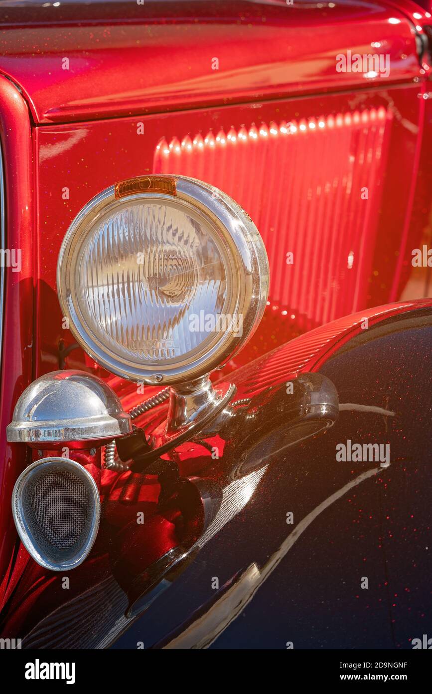 MACKAY, QUEENSLAND, AUSTRALIA - 13 luglio 2019: Primo piano del faro anteriore di auto classica rossa personalizzata Foto Stock