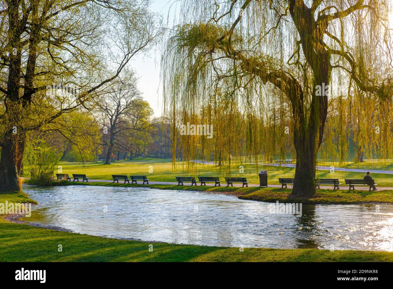 Solitario sulle panchine deserte del parco a Schwabinger Bach, Englischer Garten, Monaco, alta Baviera, Baviera, Germania Foto Stock