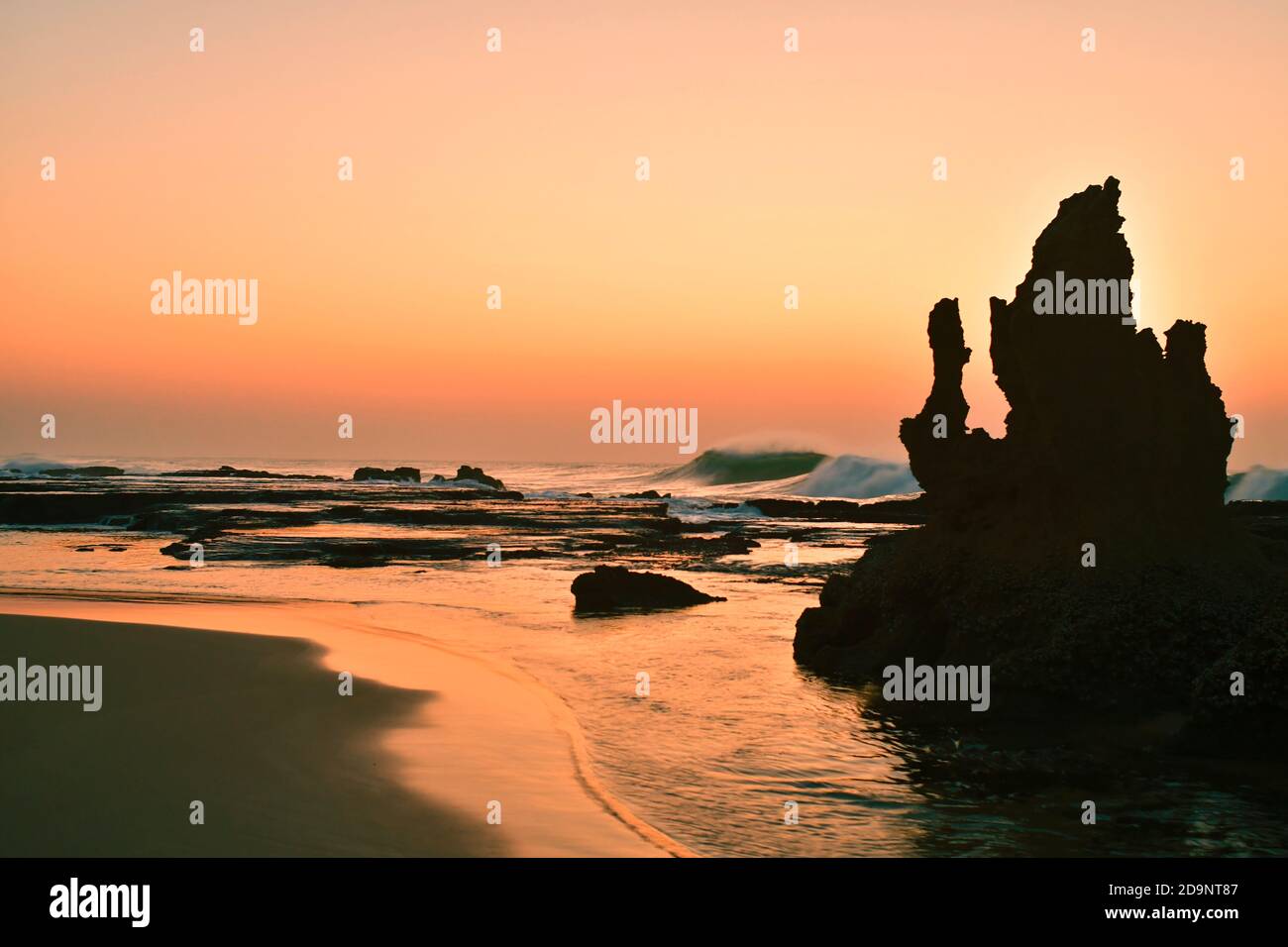 Spiaggia all'alba, formazione rocciosa, silhouette, Umhloti Beach, Durban, Sud Africa Foto Stock