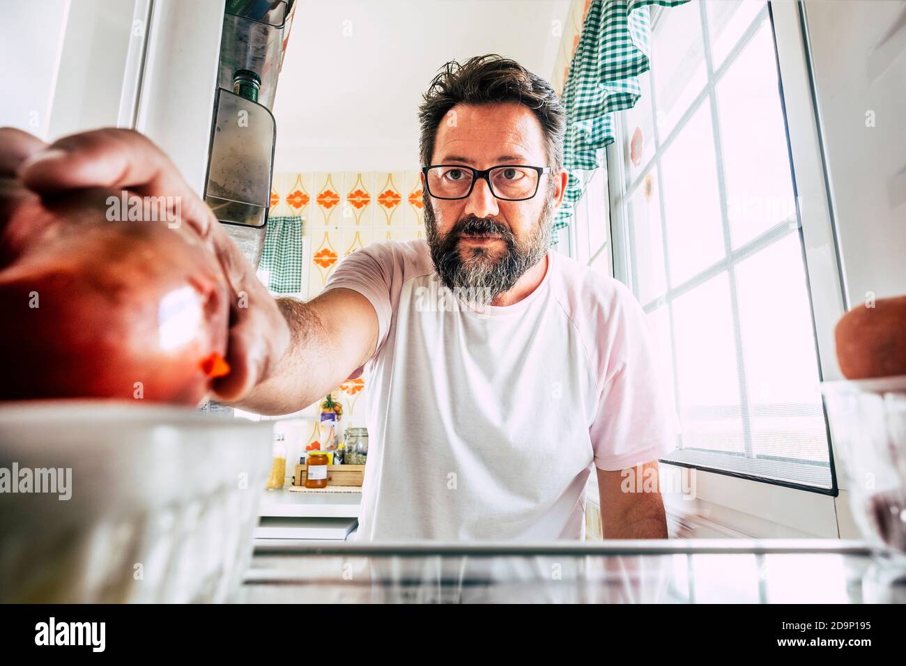 Singolo uomo solitario a casa di età adulta guardando all'interno di un frigorifero vuoto per scegliere cosa mangiare - concetto di stile di vita sano e dieta nutrizione vita alimentare a perdita di peso e guadagnare la salute Foto Stock