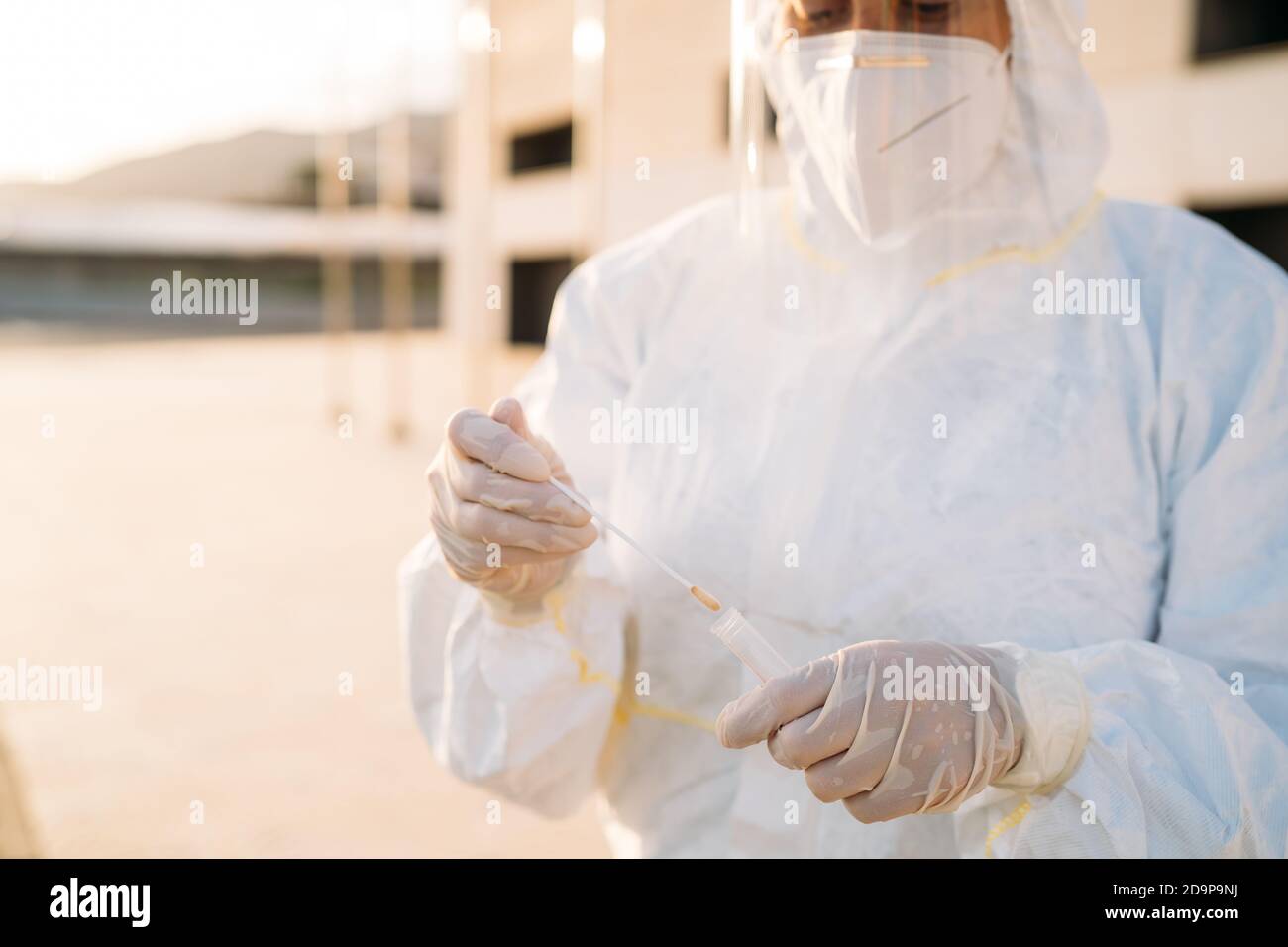 Ritratto di una giovane operatrice medica usa un test PCR su una persona all'interno di un'auto per determinare la presenza o l'assenza del Covid-19. Foto Stock