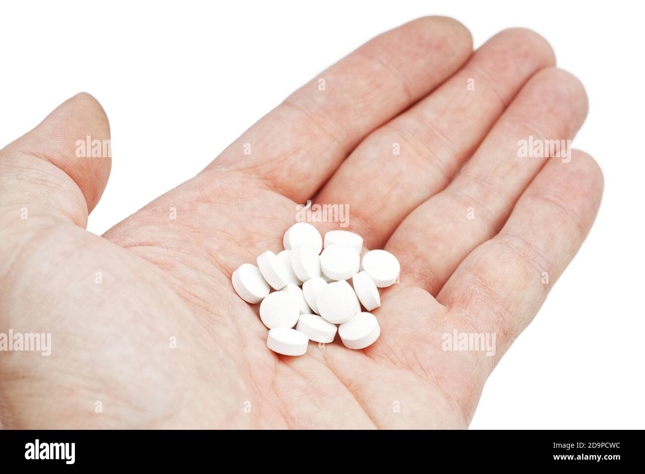 Closrup palma umana con pila di pillole bianche isolato su sfondo bianco Foto Stock