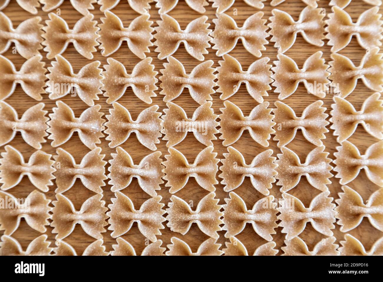 composizione di pasta di grano duro, forma di farfalle, elementi ripetuti, fondo astratto Foto Stock