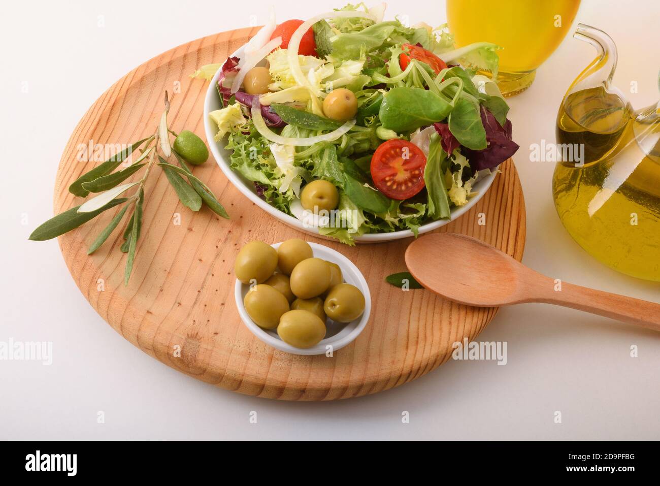 Insalata mediterranea con prodotti freschi e olio d'oliva su una panca bianca da cucina. Vista rialzata. Composizione orizzontale. Foto Stock