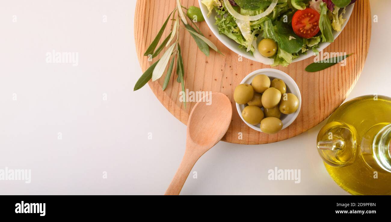 Insalata mediterranea con prodotti freschi e olio d'oliva su una panca bianca da cucina. Vista dall'alto. Composizione orizzontale. Foto Stock