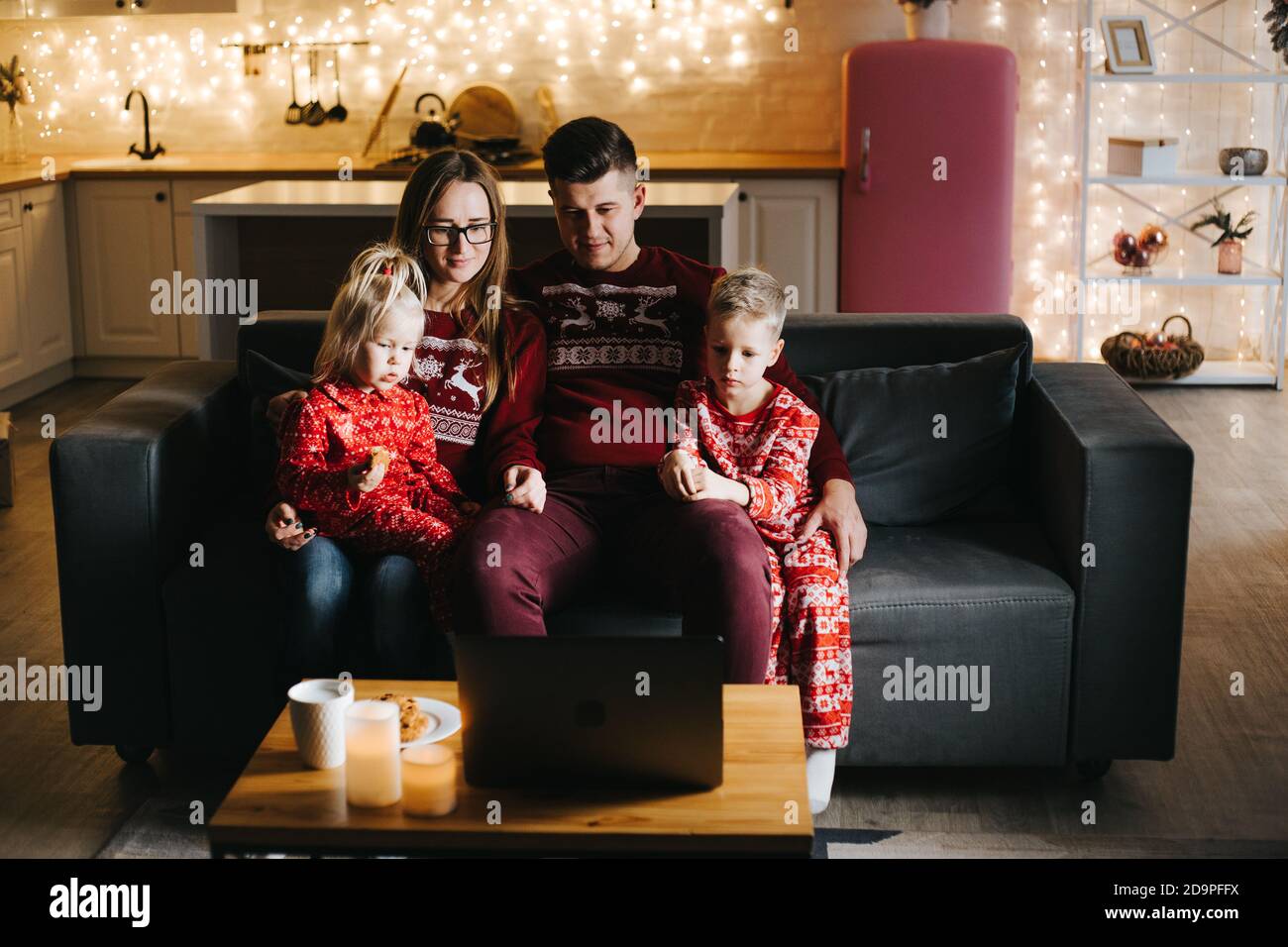 Buona famiglia che guarda un film insieme a Natale Foto Stock
